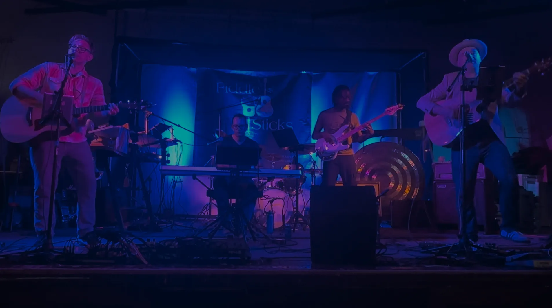 Fiddle Sticks performing on stage under blue lights